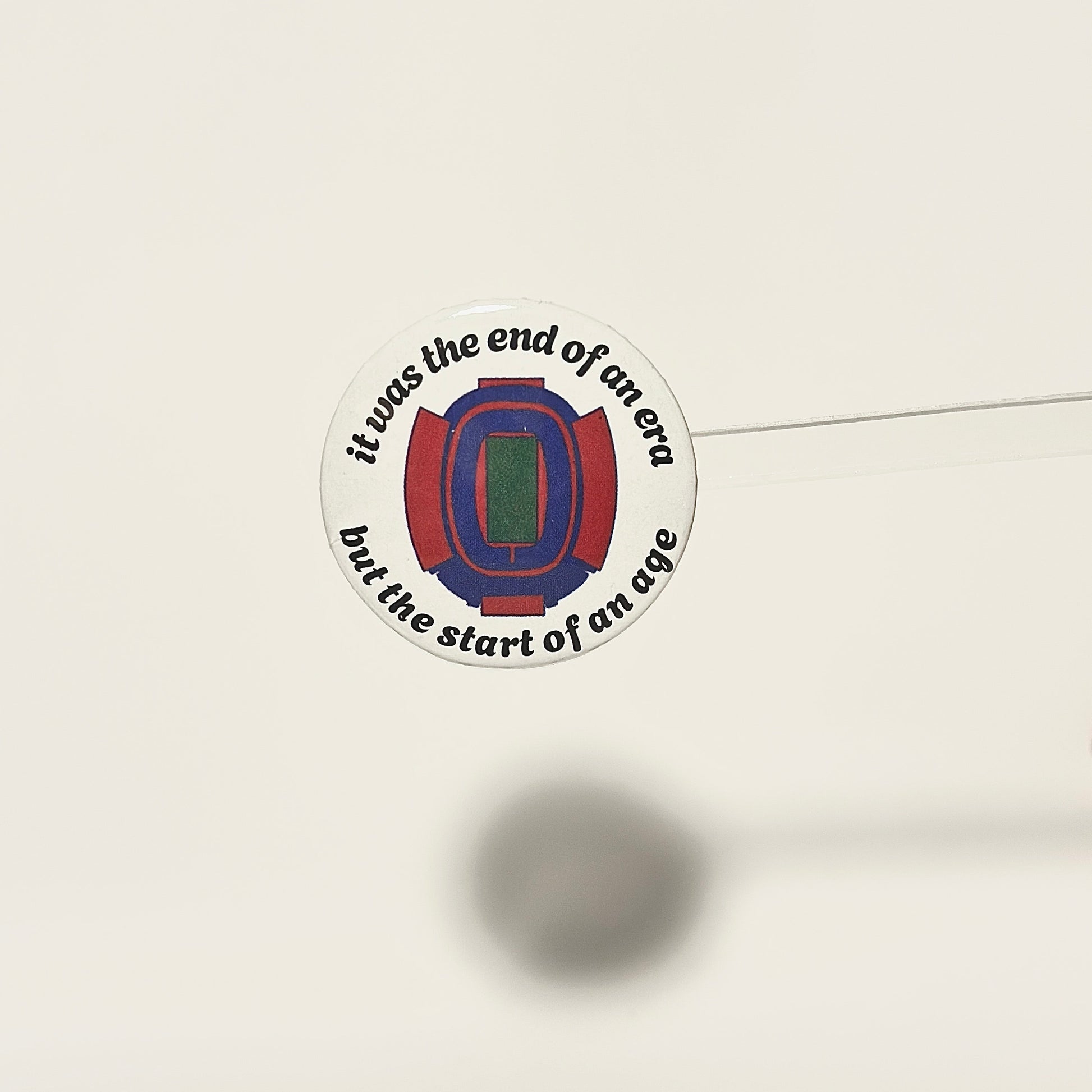 pinback button with arched text that reads it was the end of an era but the start of an age with a hand drawn version of the iconic buffalo bills stadium known as The Ralph. design is on a white background